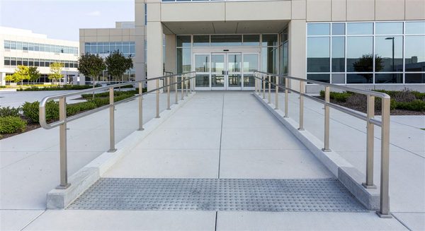 Accessible hospital entrance ramp with tactile surface and ADA-compliant handrails