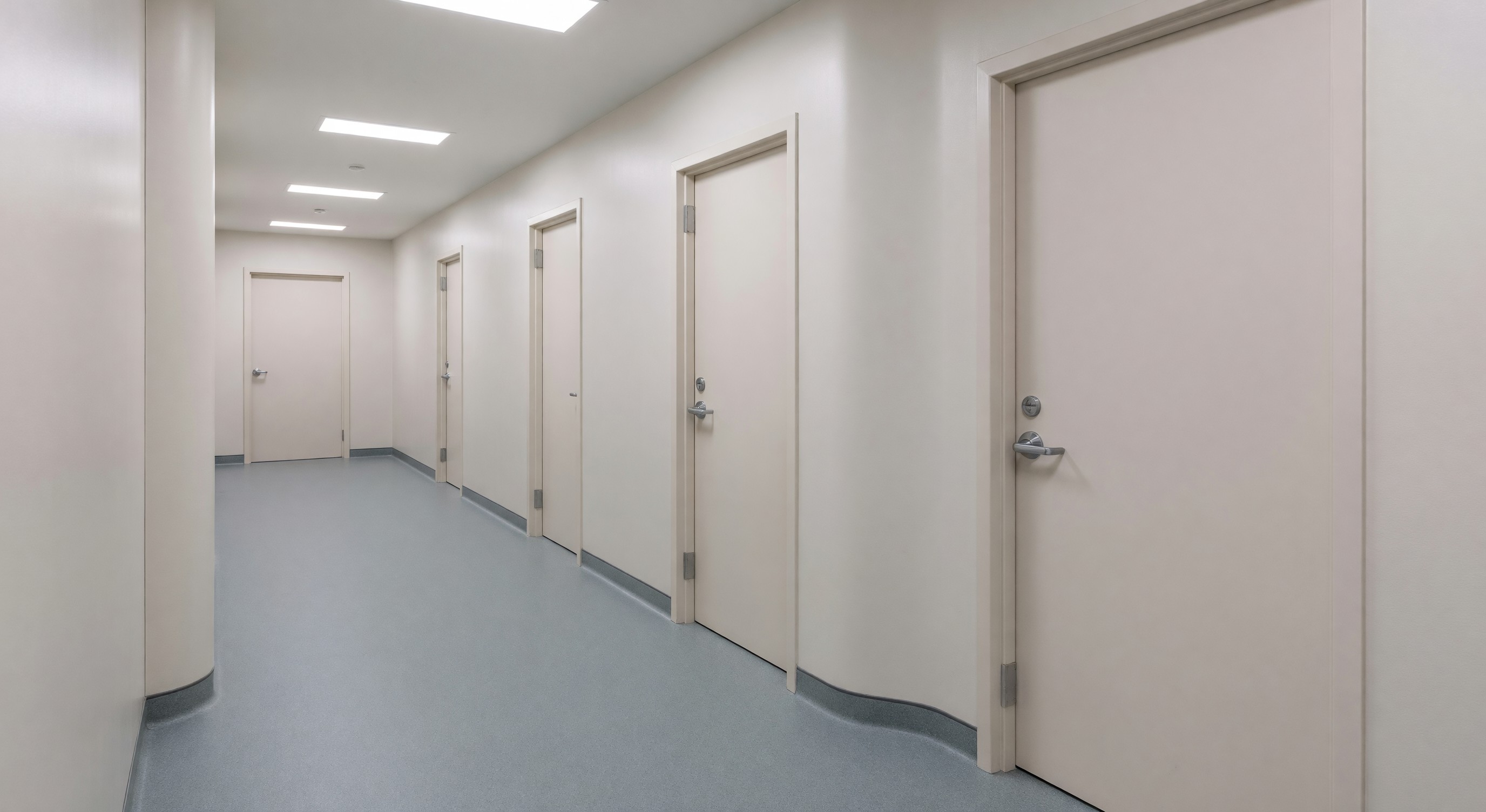 Behavioral health unit corridor with anti-ligature door hardware and rounded corner design features