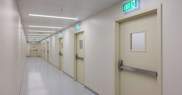 Hospital corridor showing fire door compartmentalization and egress signage compliance