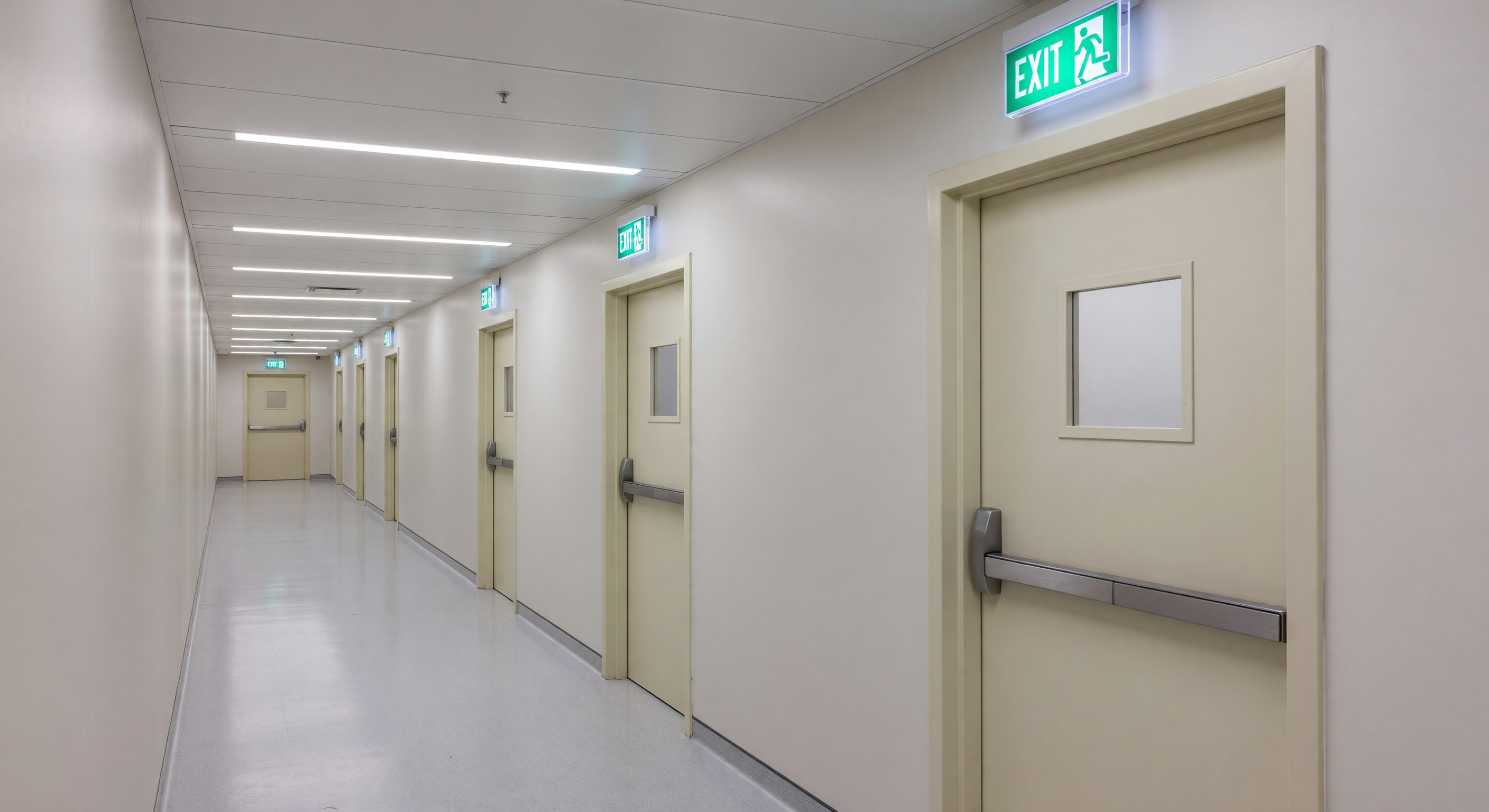 Hospital corridor showing fire door compartmentalization and egress signage compliance