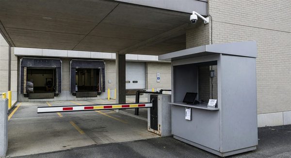 Hospital loading dock with controlled access gate, security camera, and vendor check-in station