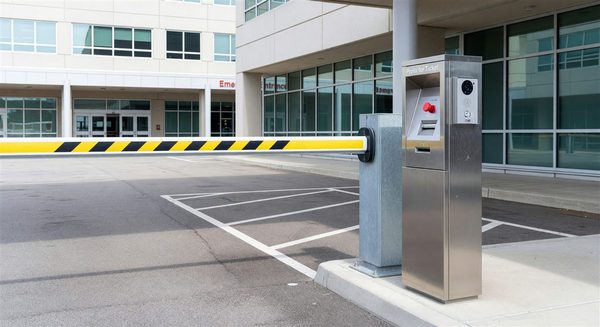 Hospital parking entry lane with barrier gate, ticket dispenser, and video intercom