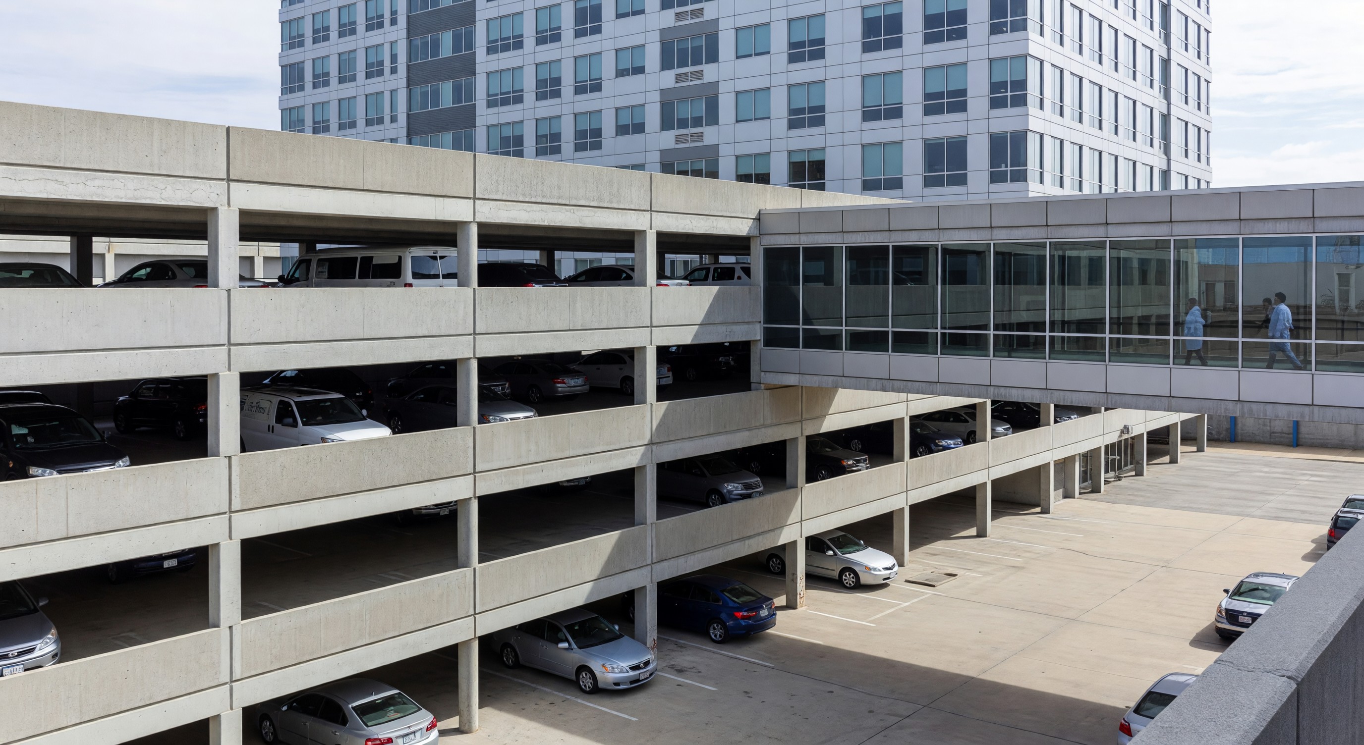 Multi-level hospital parking structure with pedestrian bridge connection to medical building