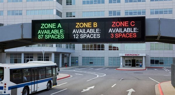 Dynamic parking guidance sign at hospital entrance showing available spaces by zone