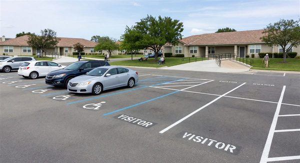 Senior living community parking area with accessible spaces and well-marked visitor zones